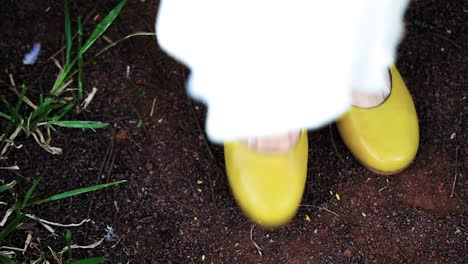 a woman legs on high fashion yellow flamenco shoes with white short dress, happy woman playing with her legs on yellow shoes