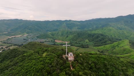 Vista-Panorámica-Sobre-La-Cruz-En-Tecalitlán-Con-Exuberantes-Montañas-Verdes,-Campos-Y-Cielo-Azul.