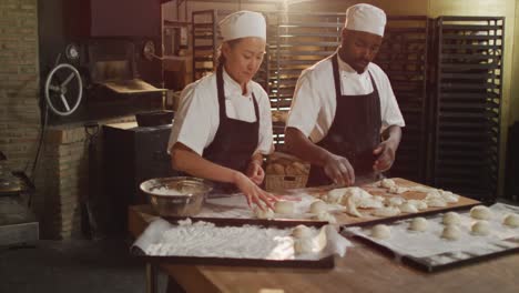 animation of diverse female and male bakers preparing rolls at bakery