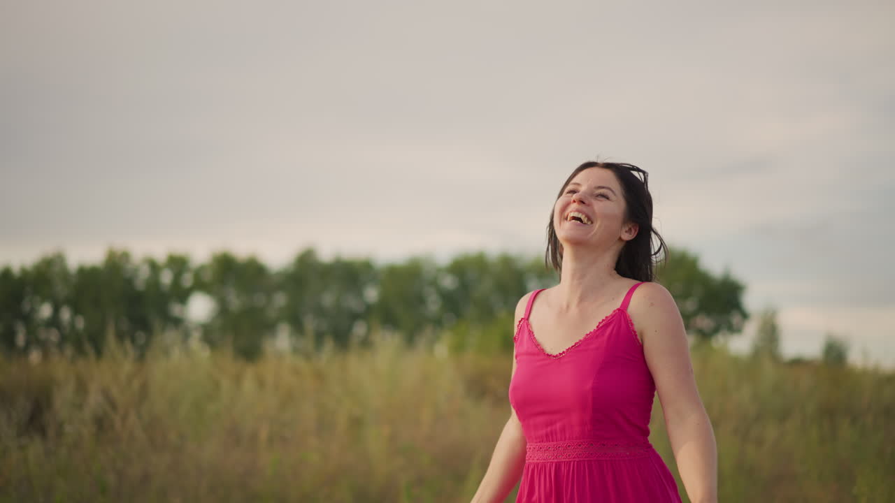 Joyful kite flying, Woman in pink dress flying kite happily, Smiling lady in meadow flying rainbow kite during sunset, Cheerful woman in colorful dress soaring kite in field at dusk