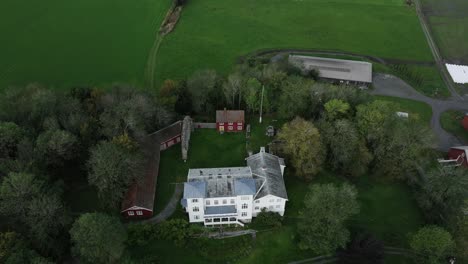 reins kloster surrounded with green fields and vegetation in rissa, norway - aerial shot