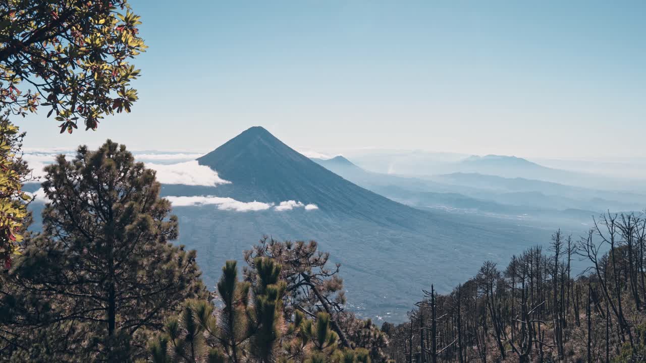 Maestosa cima vulcanica sopra un mare di nuvole e paesaggio forestale in primo piano, Guatemala