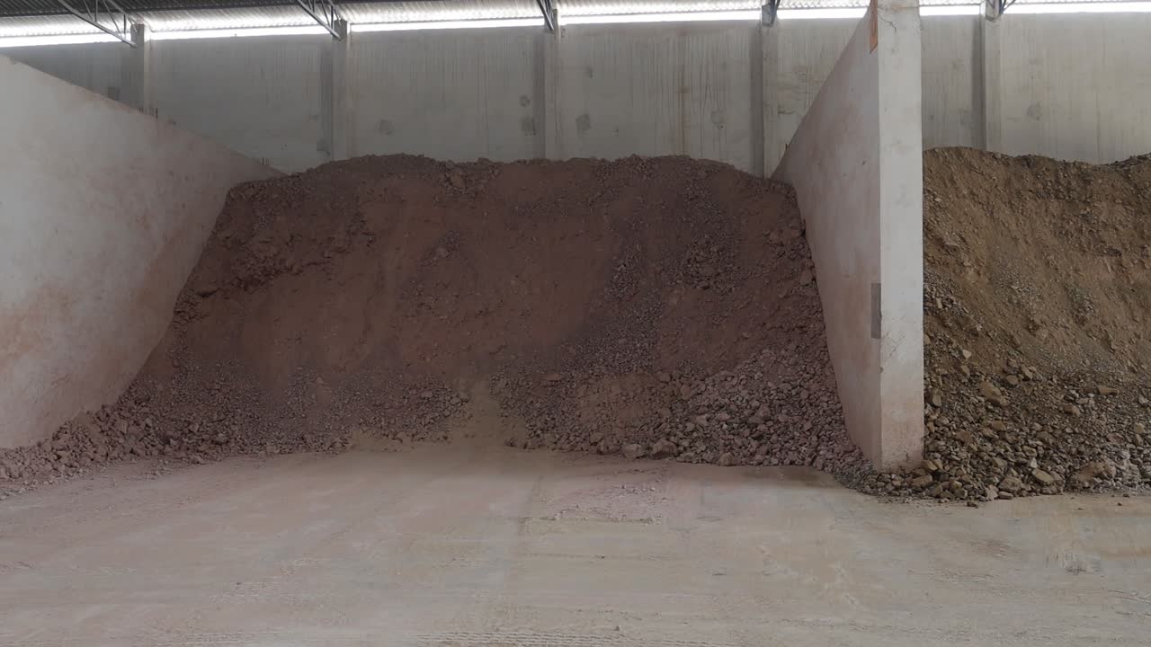 Large piles of soil and clay stored in a warehouse