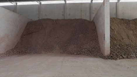 large piles of soil and clay stored in a warehouse