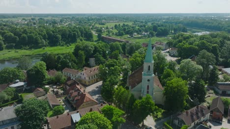 Vista-Aérea-Del-Casco-Antiguo-De-Kuldiga,-Casas-Con-Tejas-Rojas,-Iglesia-Evangélica-Luterana-De-Santa-Catalina,-Día-Soleado,-Destino-De-Viaje,-Tiro-De-Drones-Avanzando