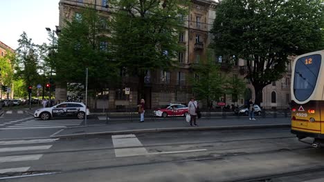 tram moves through busy milan street intersection