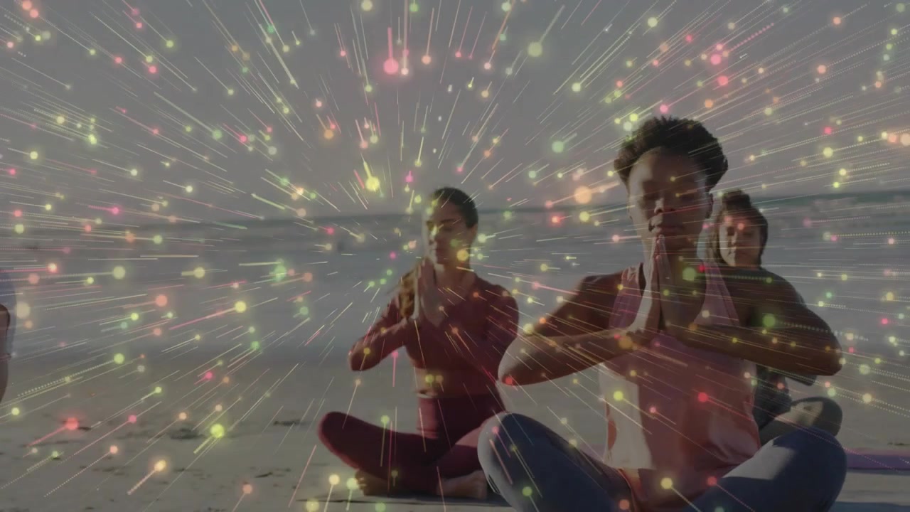 Three women raising hands for yoga breathing on beach holding prayer pose with starburst overlay