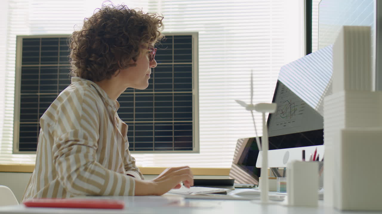 Female Renewable Energy Developer Using Tablet and Computer in Office