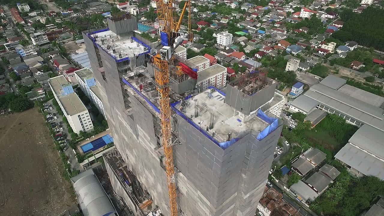 vista aérea de un moderno edificio de gran altura en construcción en el ajetreado distrito de negocios del centro de la ciudad con trabajadores, andamios y grúas