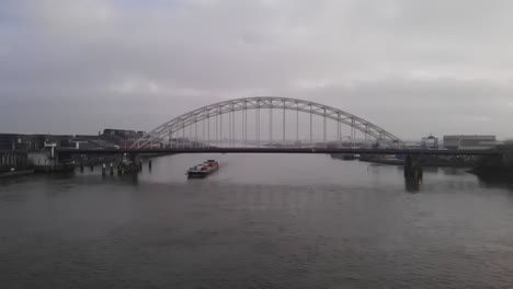 container ship passing under bridge at the river noord in netherland