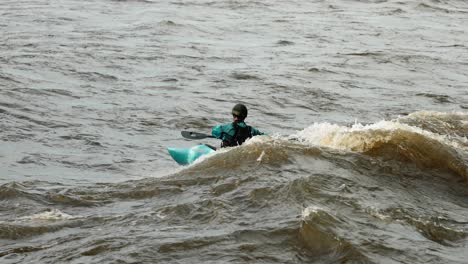 kayaker rips a swell created by the rapids on the ottawa river during high flood season