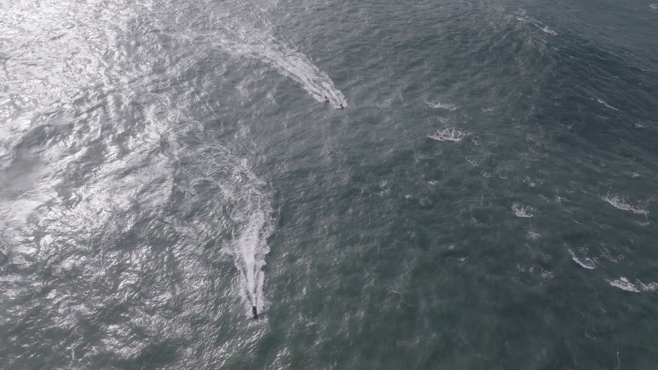 Jet ski riders at famous iconic Nazaré, nature aerial drone shot. Home of biggest waves in the world