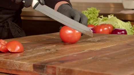 Juicy-ripe-red-tomatoes-being-sliced-on-a-wooden-chopping-board,-slow-mo