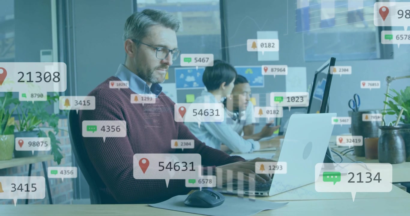 Mies kirjoittaa kannettavalla tietokoneella tiimin kanssa toimistossa, kun kelluvia analytiikkakuvakkeita ilmestyy ja kehittyy pylväsdiagrammiksi.