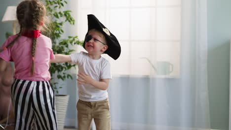 toddler boy in pirate costume attacks sister with toy sword