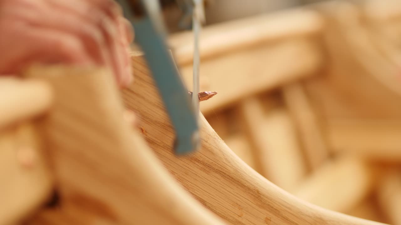 Hacksaw Cutting Copper Nail in Oak Wood Boat Close Up