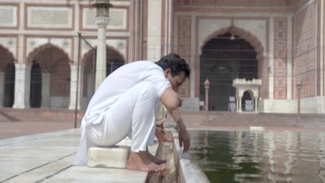 hombre musulmán indio haciendo wuzu en jama masjid delhi