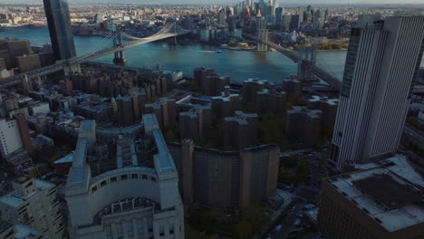 Aerial-footage-of-Brooklyn-and-Manhattan-bridge-across-East-river.-Tilt-up-reveal-of-downtown-high-rise-buildings.-Manhattan,-New-York-City,-USA