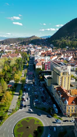 aerial view of city center of brasov, romania. view of main bulevard of the city. drone going forward above the city. famous travel destination. carpathian mountains in background. vertical footage.