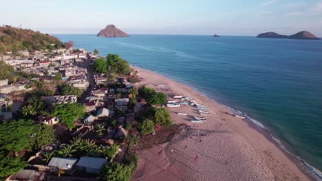 Niños-Jugando-Al-Fútbol-Y-Muchos-Botes-En-Una-Playa-Al-Lado-De-Un-Pueblo-Rural-En-África