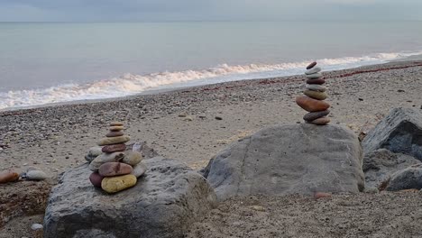close-up image of stone mounds by the calmy waving ocean, on a cloudy fall afternoon in spain
