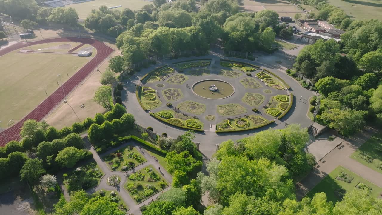Italian style gardens surrounded by green trees next to running track. Stanley Park, Blackpool, Lancashire, UK.