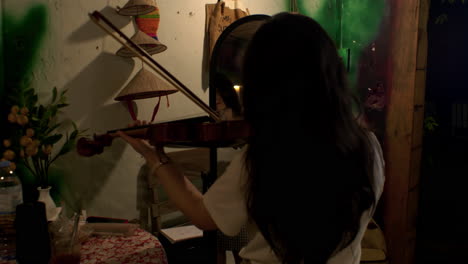 female violinist musician immersed in playing melodic tunes in front of mirror