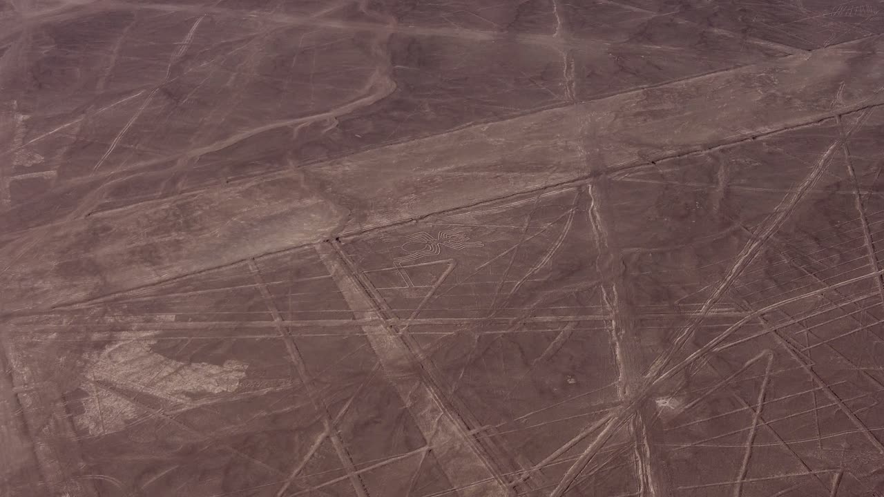 Aerial video of the famous Nazca Lines. Drone flies above many long linear geoglyphs and a depiction of a spider. Located in desert plateau of Nazca, Peru