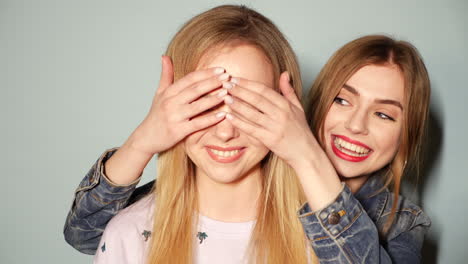 two happy women playing a surprise game