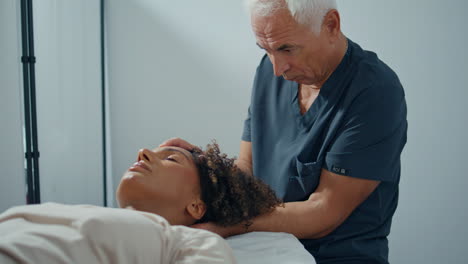 closeup chiropractor checking woman on couch. mature physiotherapist examine