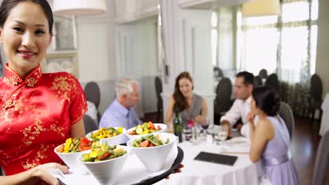 Happy-waitress-presenting-tray-with-bowls-of-vegetables