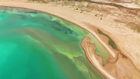 aerial view of serene beach and clear turquoise water during golden hour