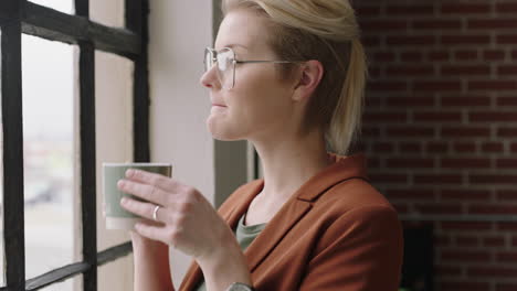 portrait stylish caucasian business woman drinking coffee at home enjoying successful lifestyle looking out window planning ahead relaxing in cozy apartment loft