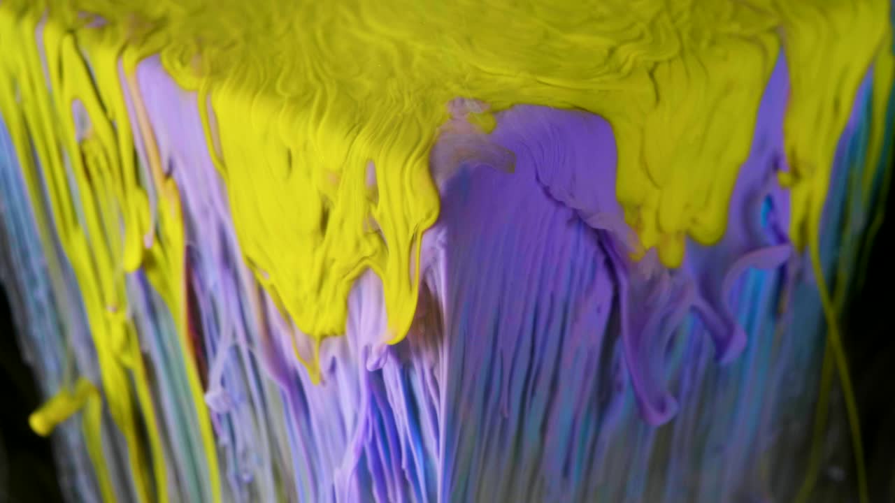 pintura de tinta multicolor fluye lentamente desde el cubo bajo el agua