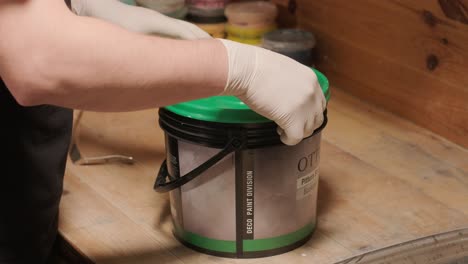 a worker open bucket the paint for painting the walls