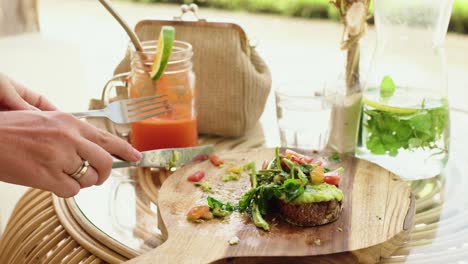 woman having lunch cut green healthy sandwich in cafe