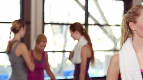 fit woman smiling at camera in gym
