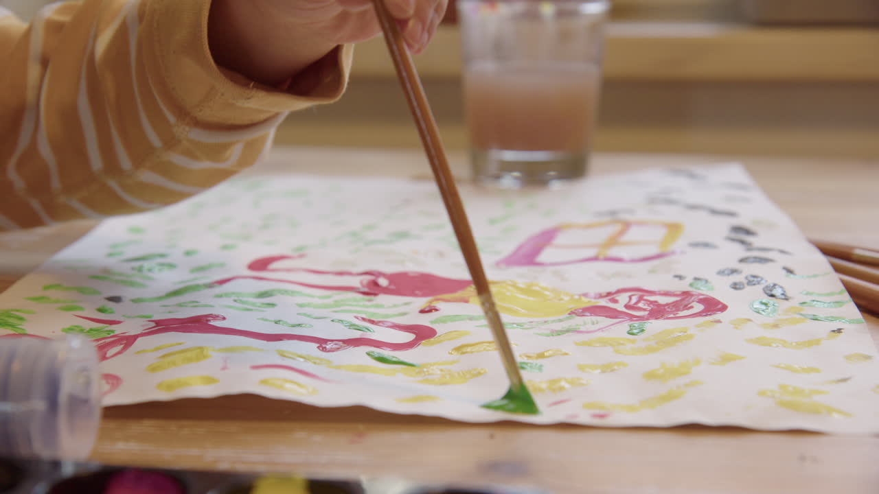 クローズアップ、ラックフォーカス、絵筆が緑色の絵の具に浸され使用される。