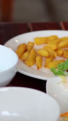 hands arranging sugarcane shrimp on a plate