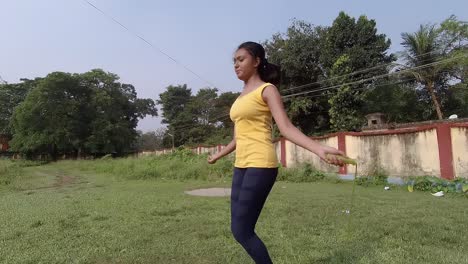 young asian teenage girl practicing skipping rope and failing on ground at sunny morning