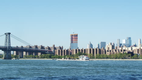 ship on hudson river with skyline and williamsburg bridge