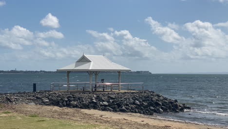 Small-Picnic-Shelter-On-the-Beach,-Windy-Day-Low-Tide,-Ocean-Waves-on-Beach