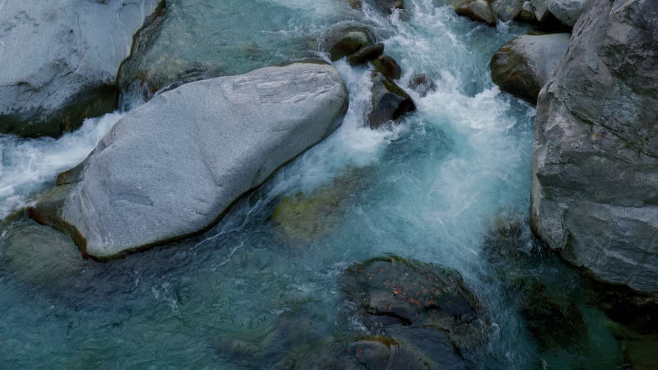 una poderosa corriente torrencial está corriendo sobre las rocas gigantes en el pueblo de cavergno, suiza.