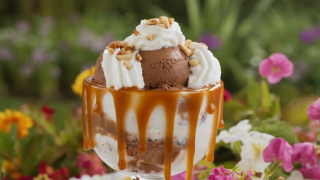 delicious ice cream sundae with caramel and peanuts in a garden setting