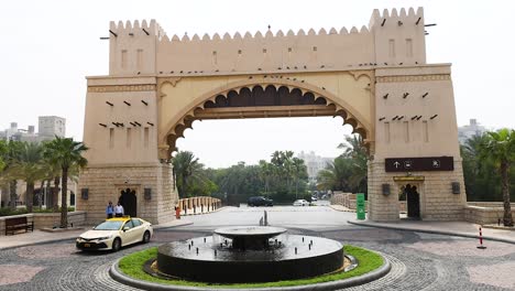 taxi approaches gate near fountain in dubai