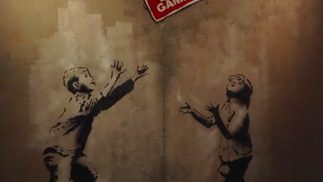 banksy-style graffiti of two children playing ball