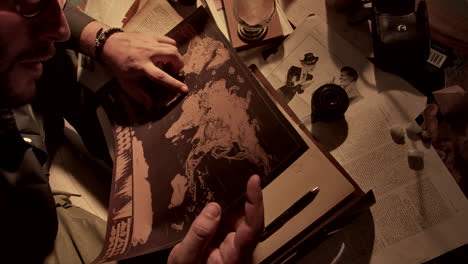 person examining an antique world map