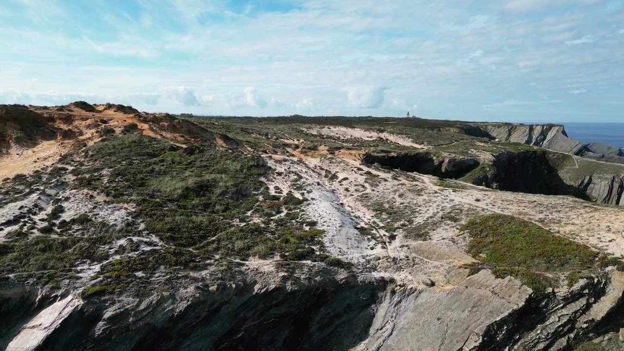 Letecké záběry dronem Praia do Cavaleiro, Portugalsko: drsné atlantické útesy, oceánské vlny a dramatická pobřežní krajina za přirozeného světla. Ideální pro cestovní a přírodní projekty.