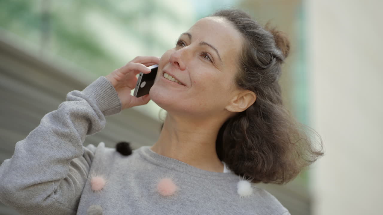 una mujer feliz de mediana edad hablando por teléfono.