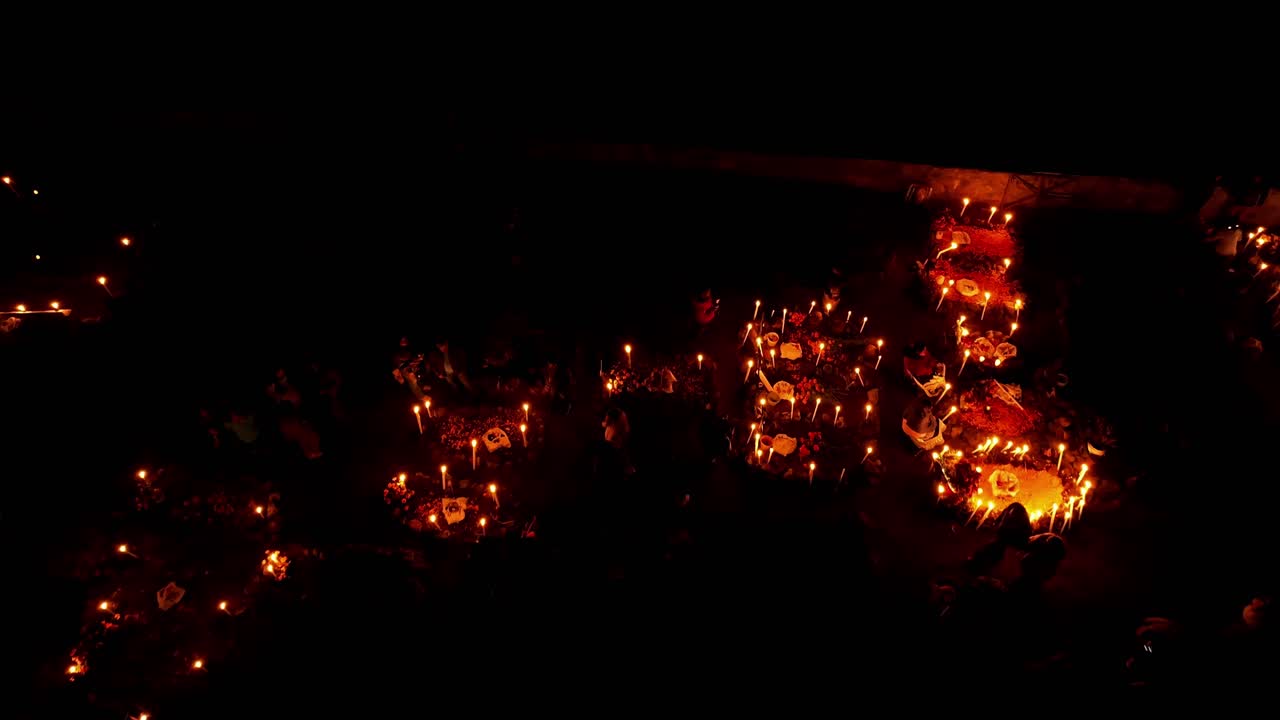 DRONE : DOLLY IN OF A GRAVEYARD IN JANITZIO ISLAND IN PATZCUARO MICHOACAN AT DAY OF THE DEATH